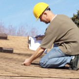A person investigating roof shingles